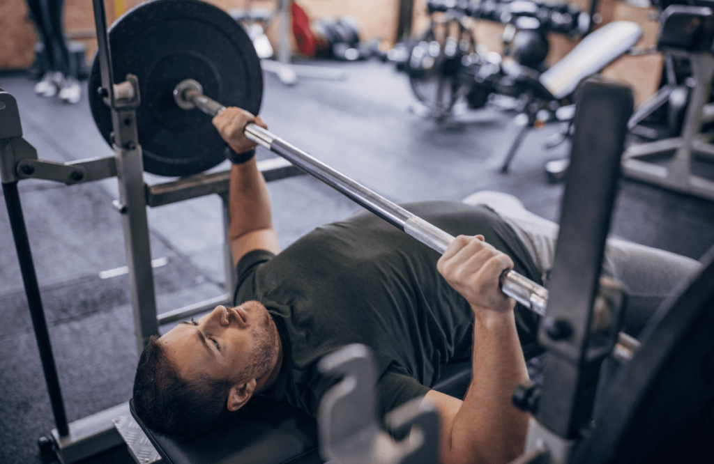Man with army shirt does bench press