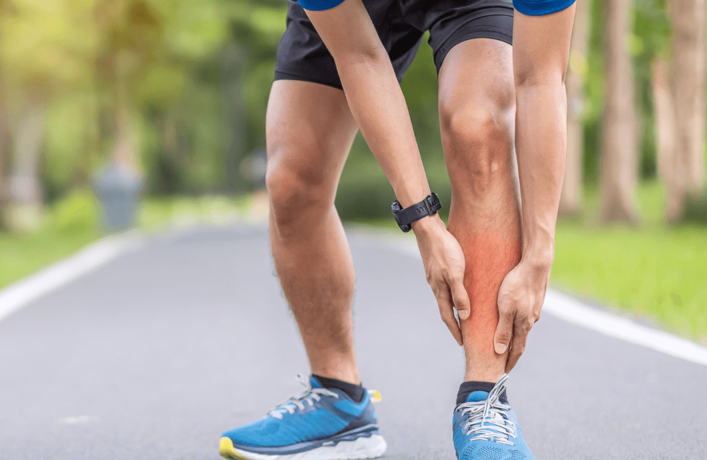 A man holds his calf in pain