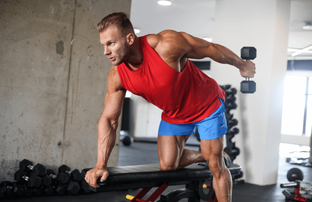 A man does tricep kickbacks in a gym