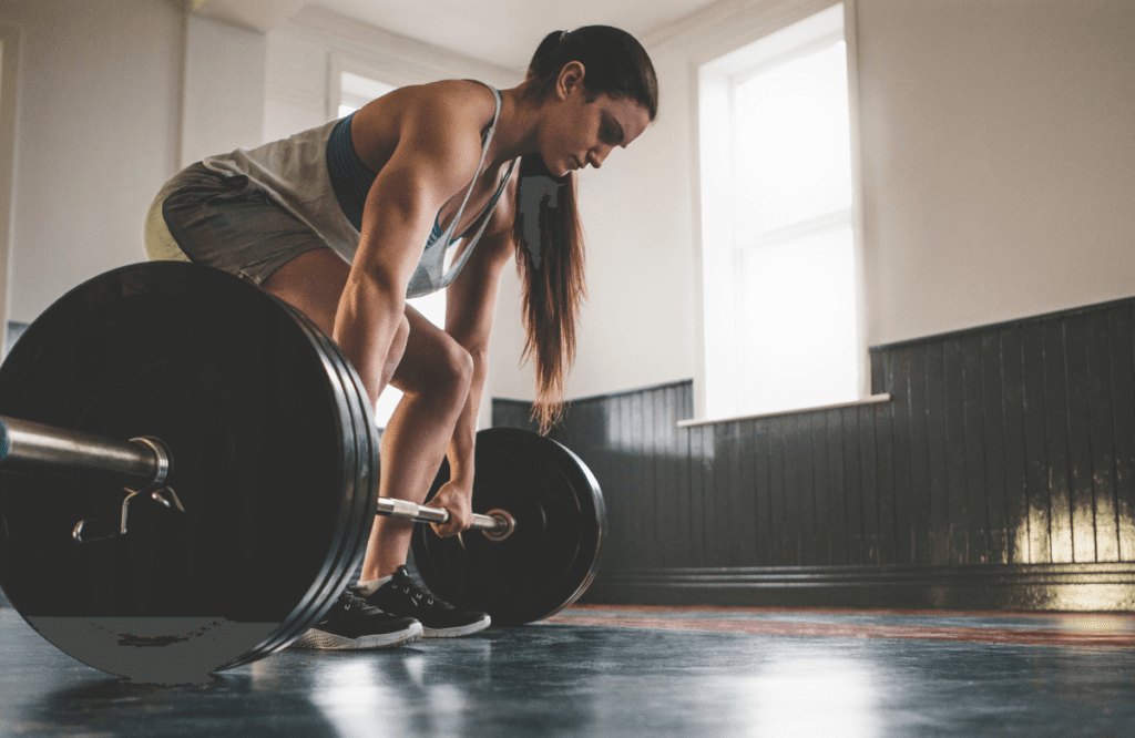 A woman does deadlifts in a gym