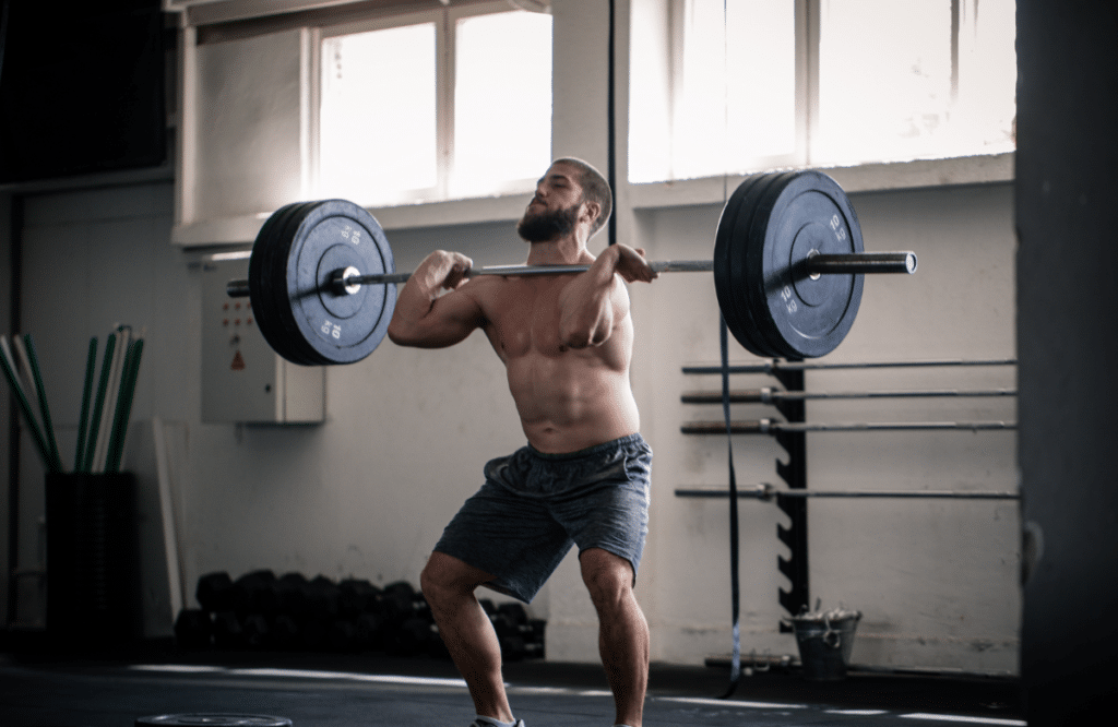 A man lifts a heavy barbell in a gym