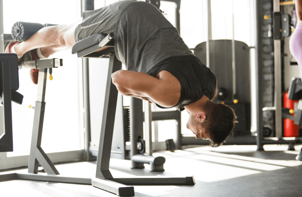 Man doing bench back extensions in gym