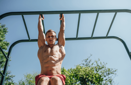 A man does neutral grip pull-ups outside