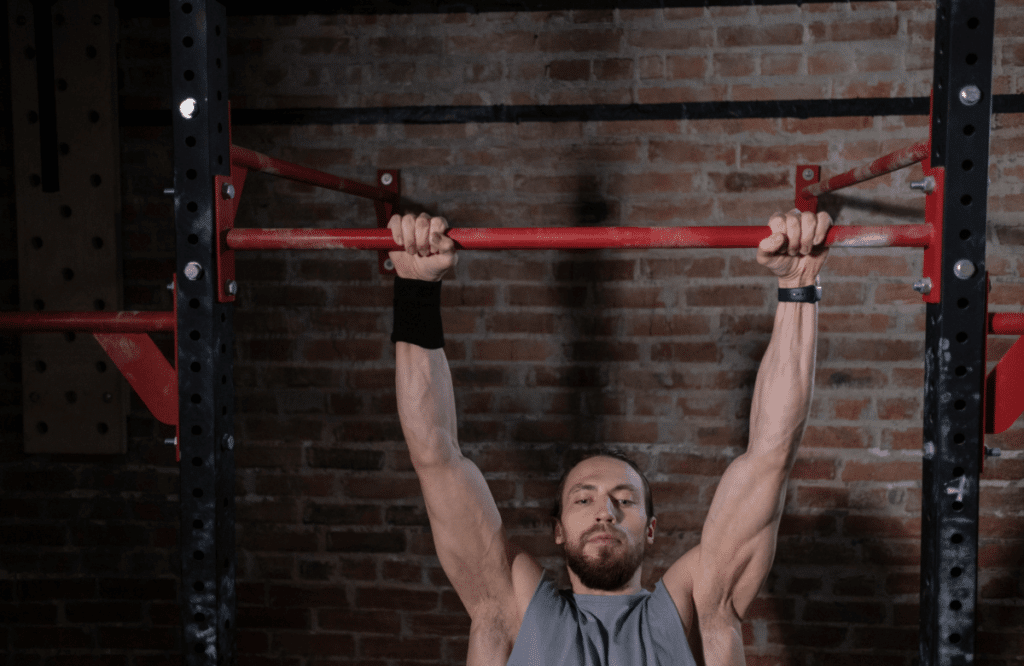 Man does a wide grip pull up