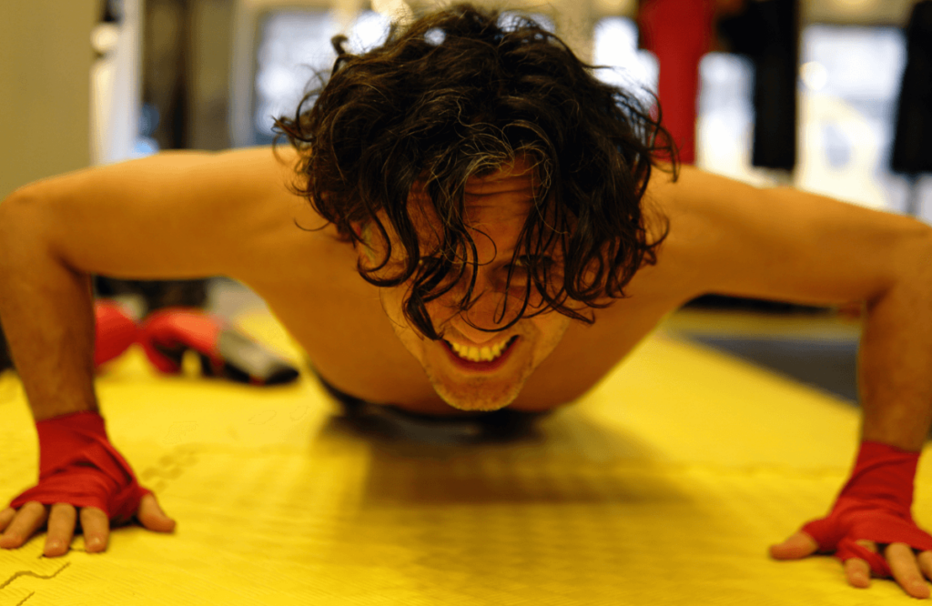 A man does push-ups on a gym mat
