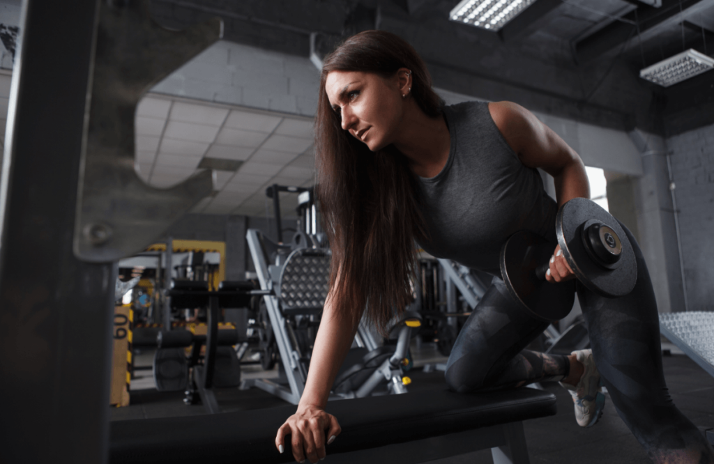 A woman does dumbbell supine rows