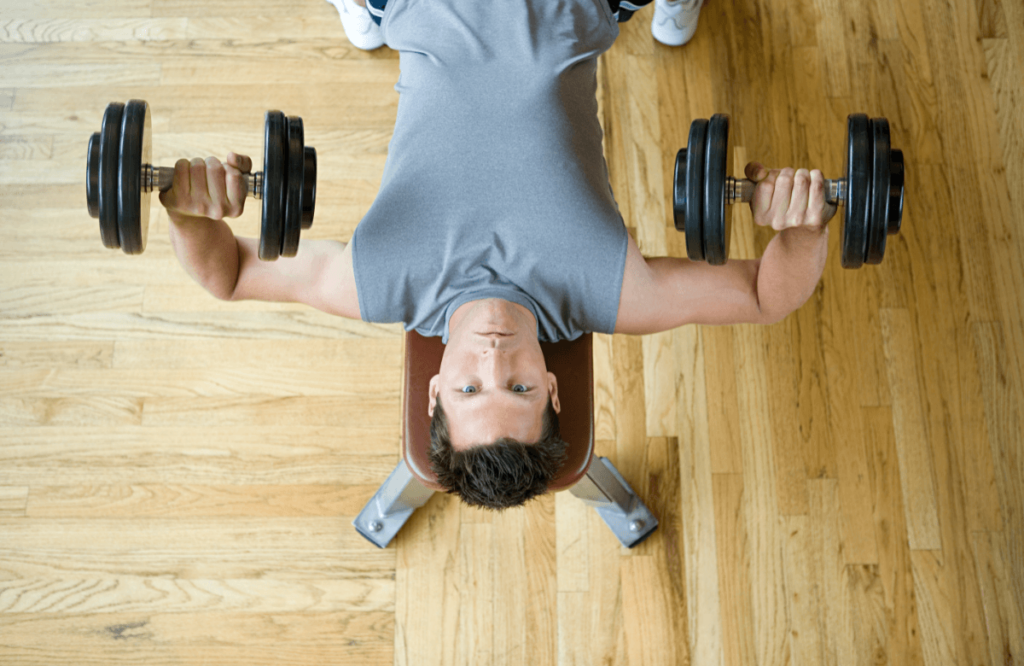 A man does dumbbell bench press
