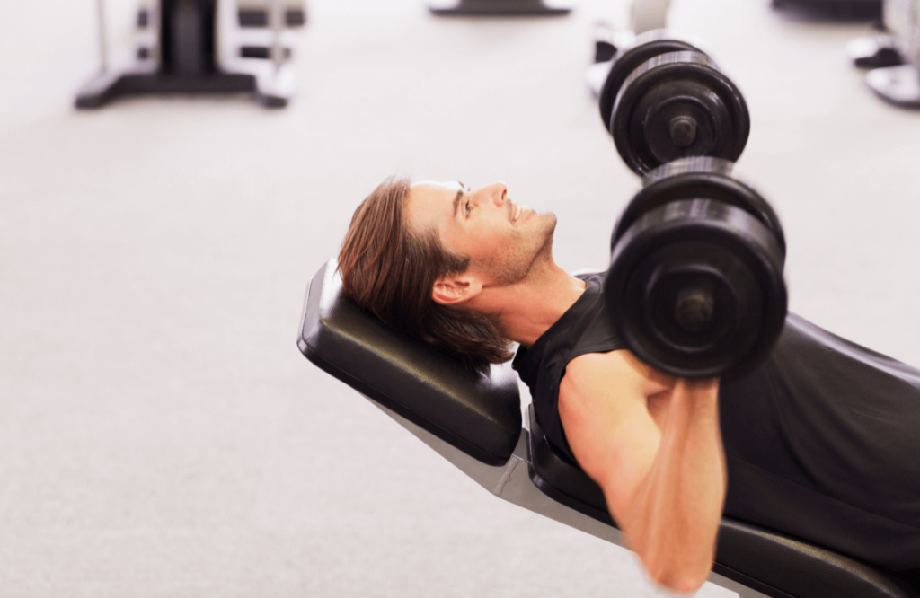 A man does dumbbell incline press