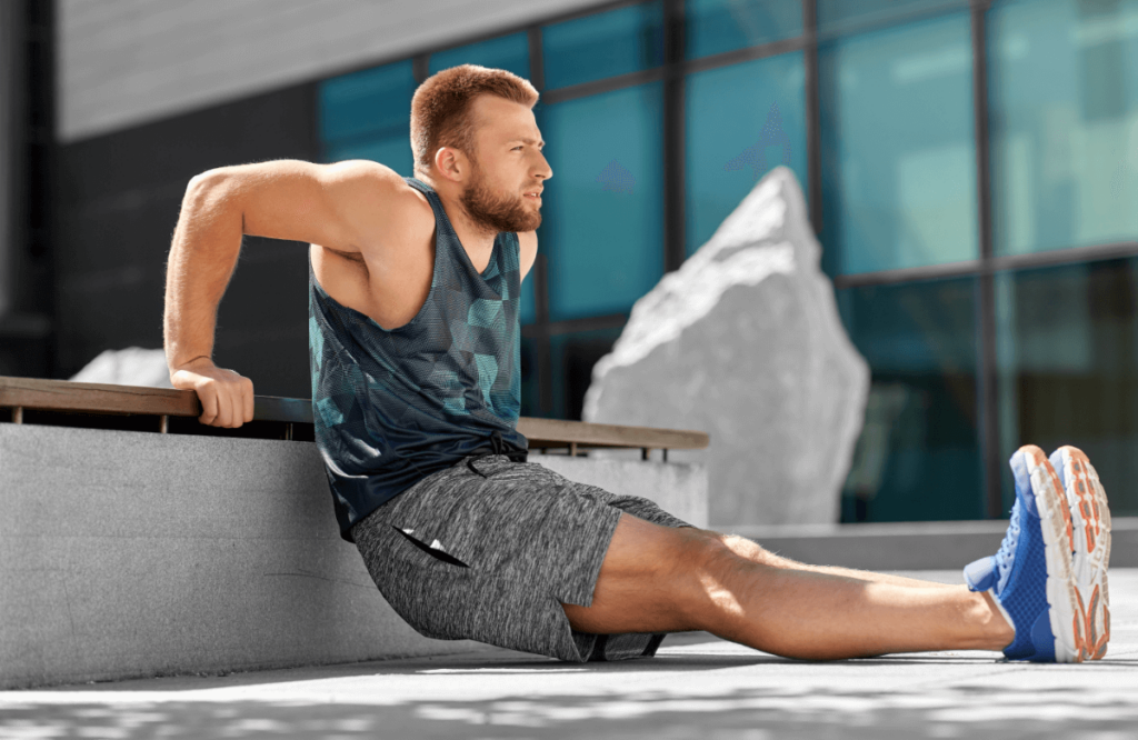 A man does dips on a bench