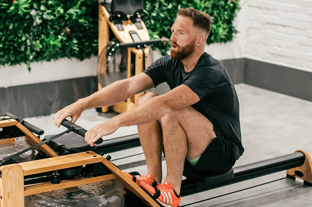 a man trying the benefits of water rowing machine