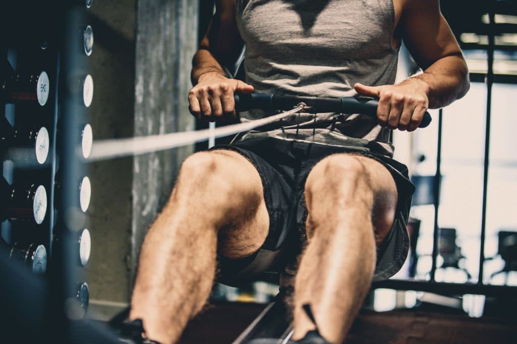 a man showing what does rowing machine work