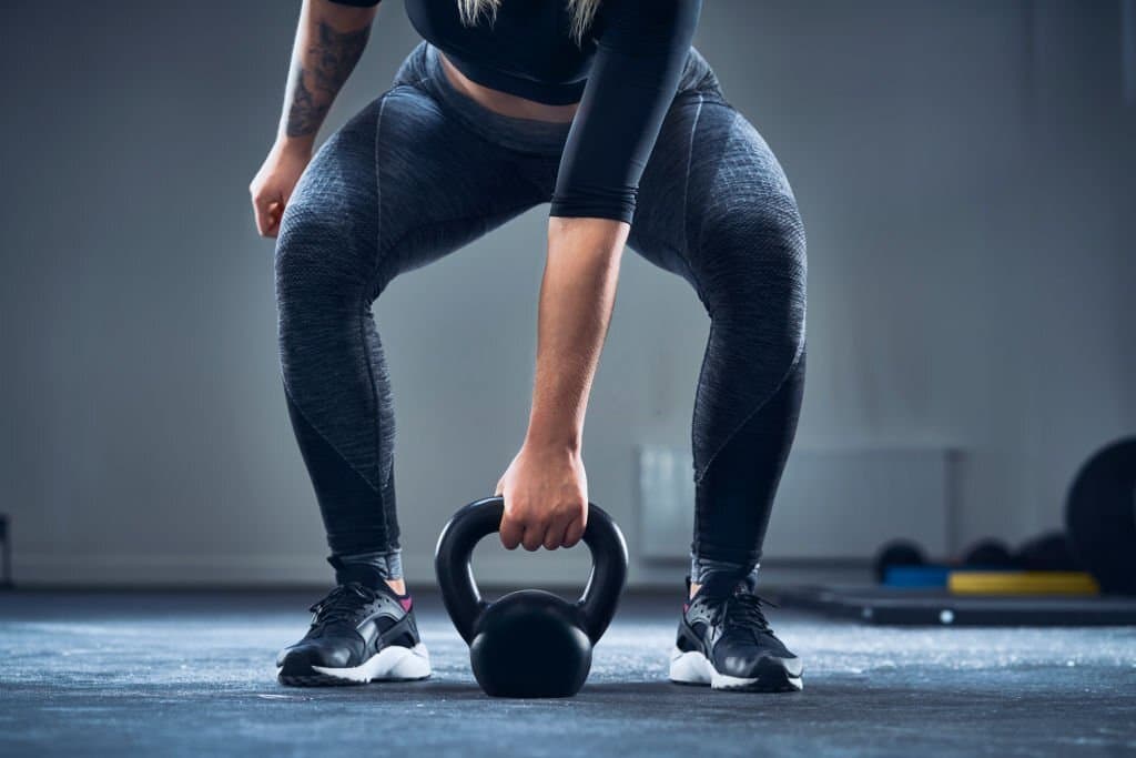 A woman training with kettlebell for its nice benefits