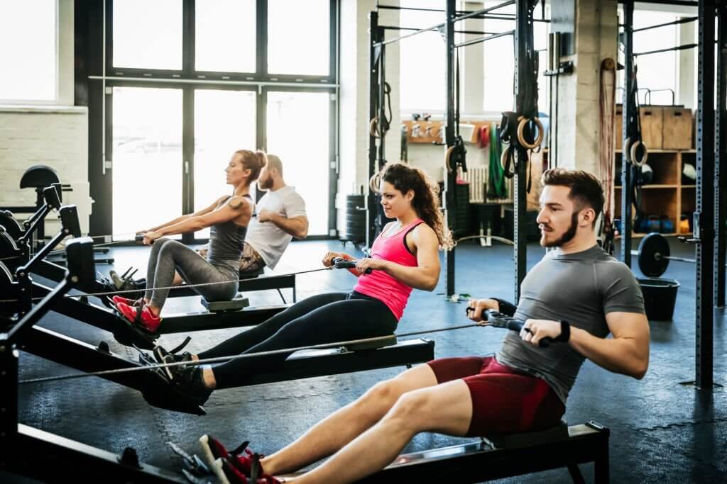 people doing resistance training on rowing machine