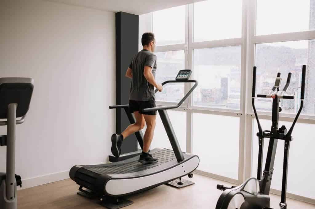 A man trying slat treadmill vs belt at the gym