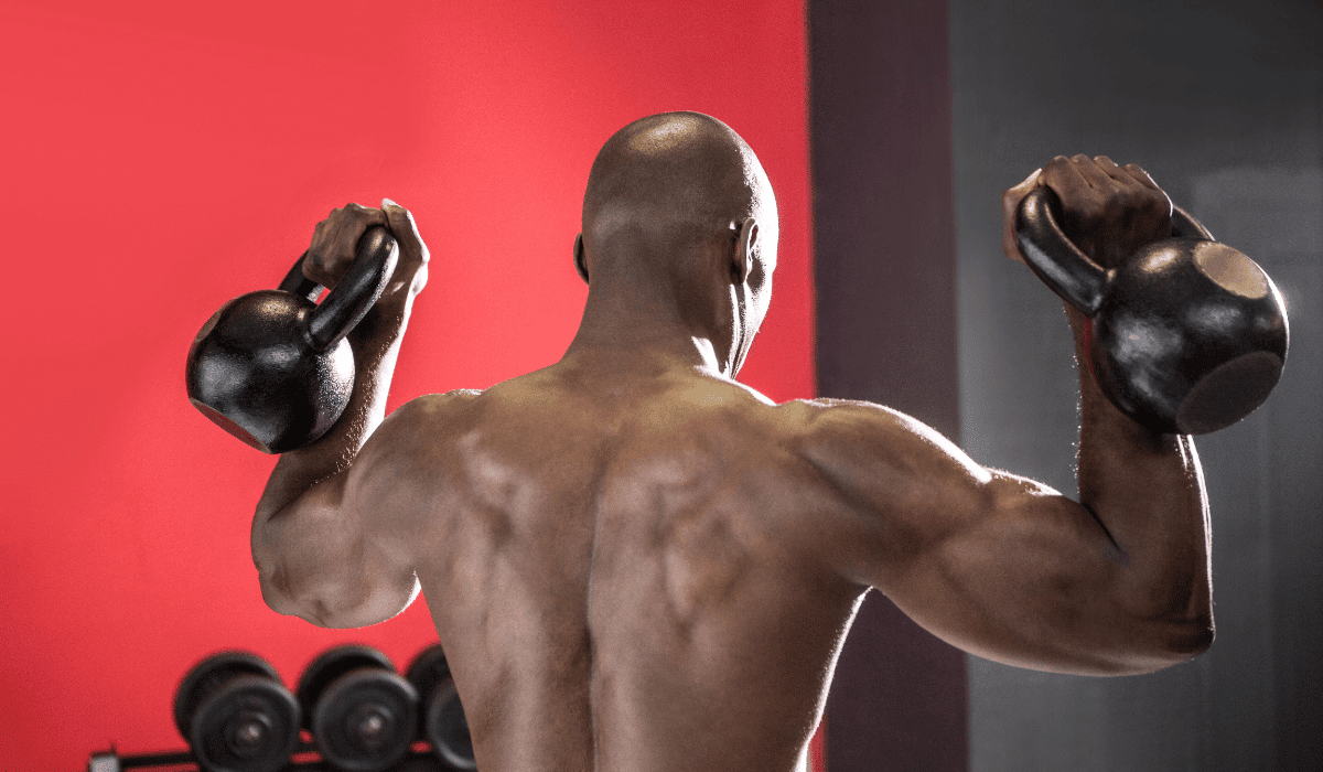 A man doing back exercises with kettlebells at the gym