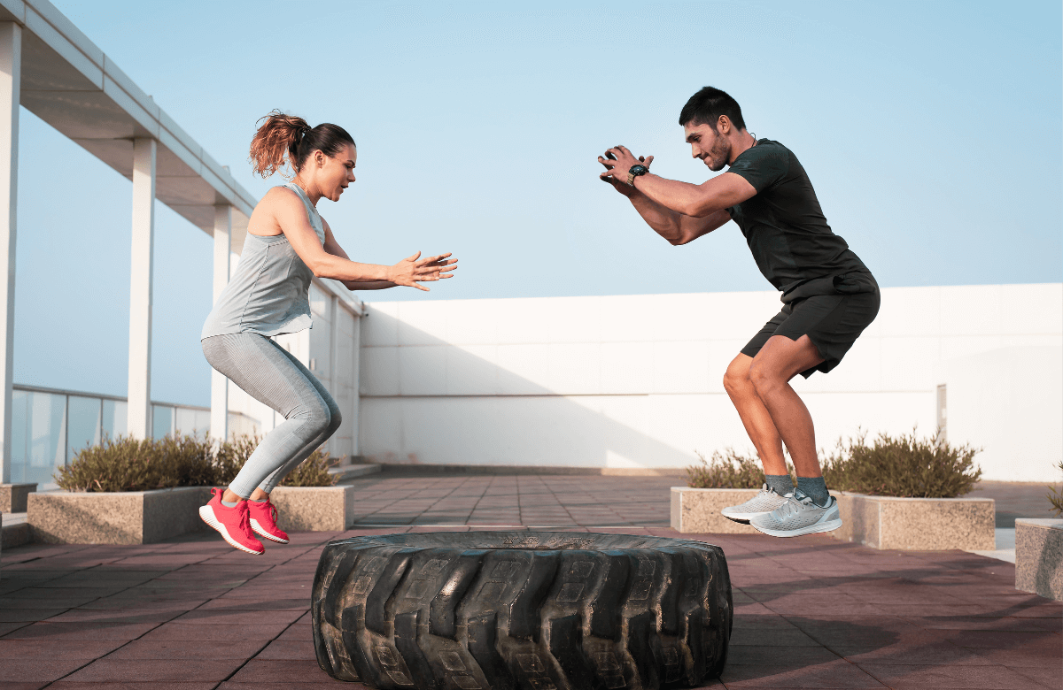 Un homme et une femme réalisent des jump squats en extérieur (exercice de pliométre)