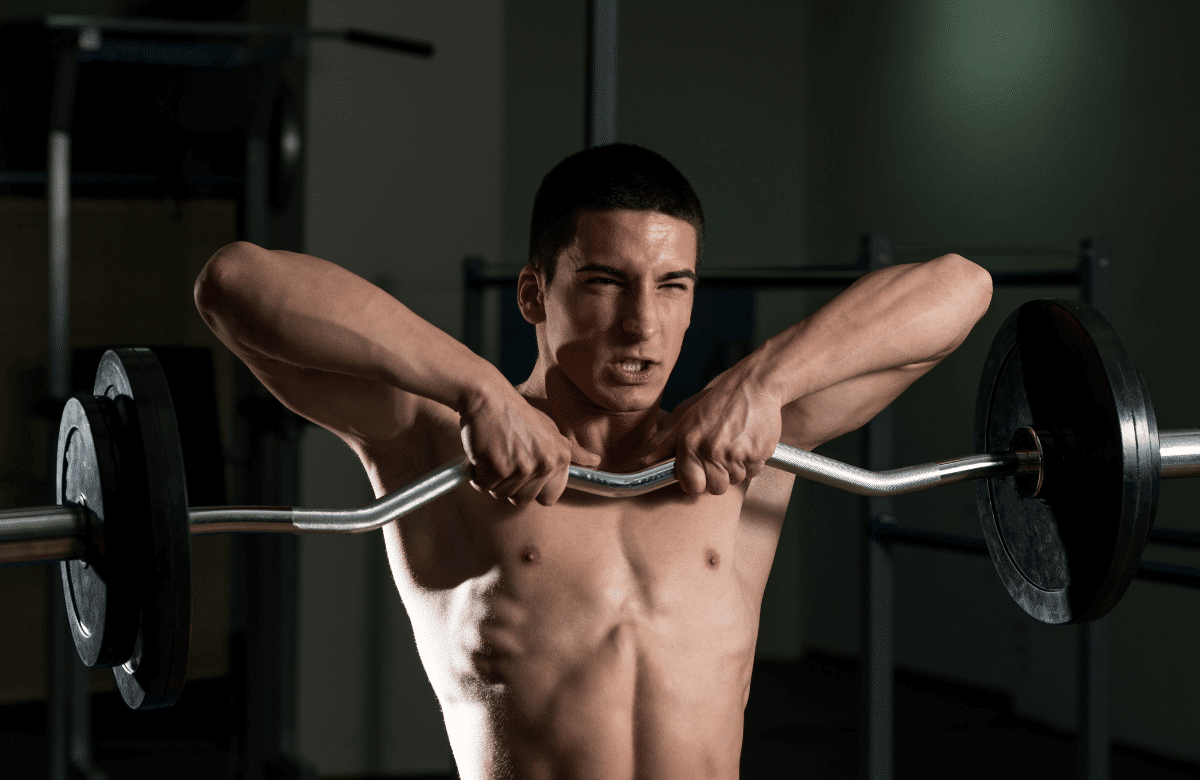 A man at the gym performing trap exercises