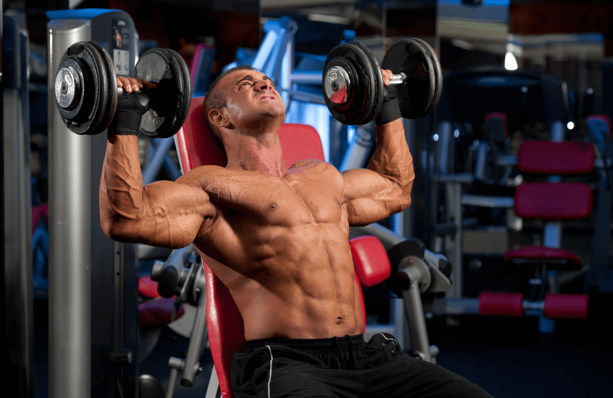A man performing a shoulder workout with dumbbells