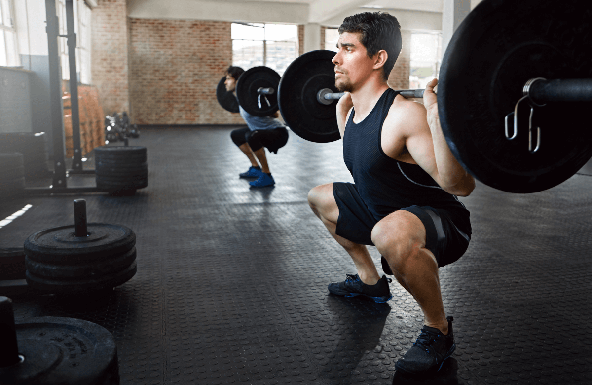 A man performing the best squats for hamstrings at the gym