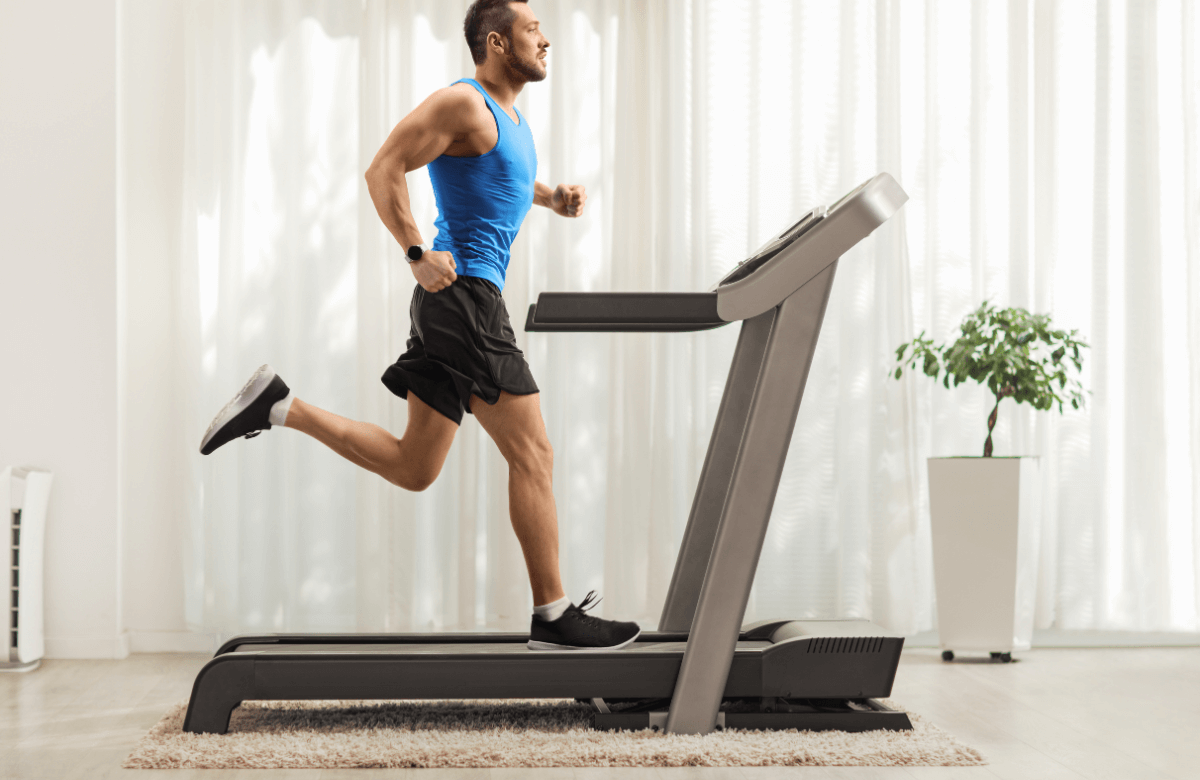 A man running on a treadmill which is on a carpet