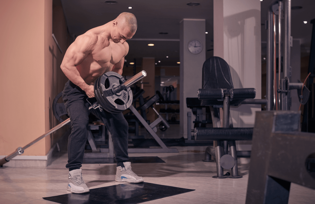A muscular man doing the t-bar row exercise
