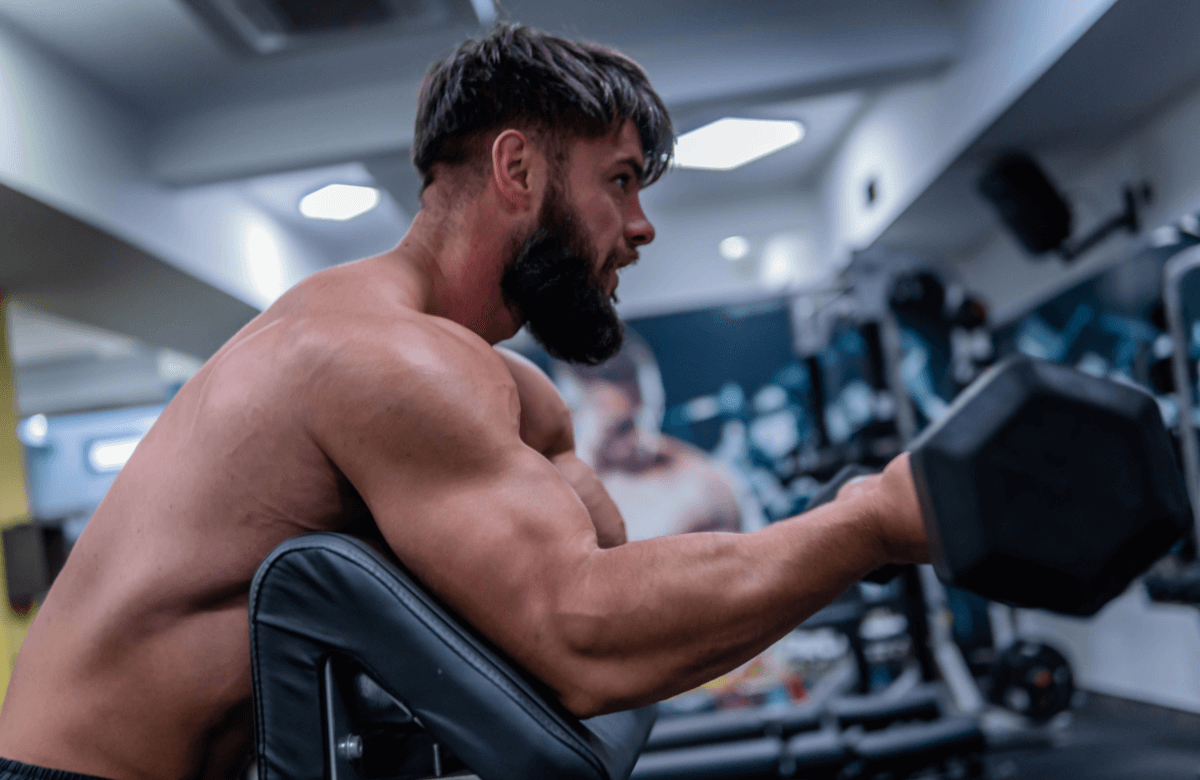 Hombre musculoso en la máquina de remo en el gimnasio