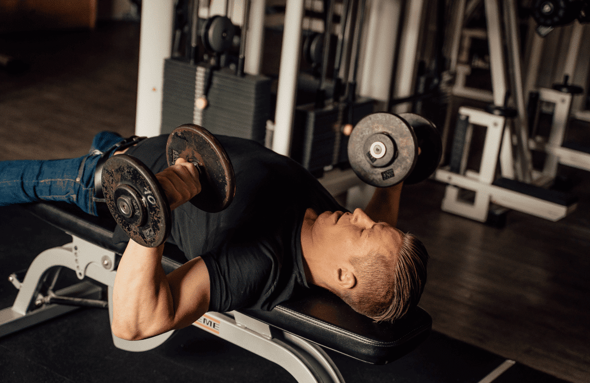 A man does dumbbell bench press