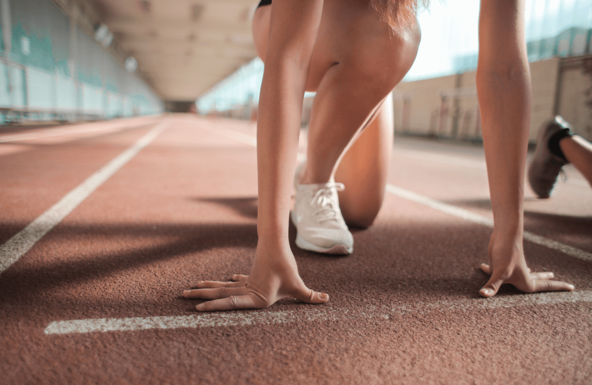 Une femme s'apprête à courir sur un piste d'athlétisme