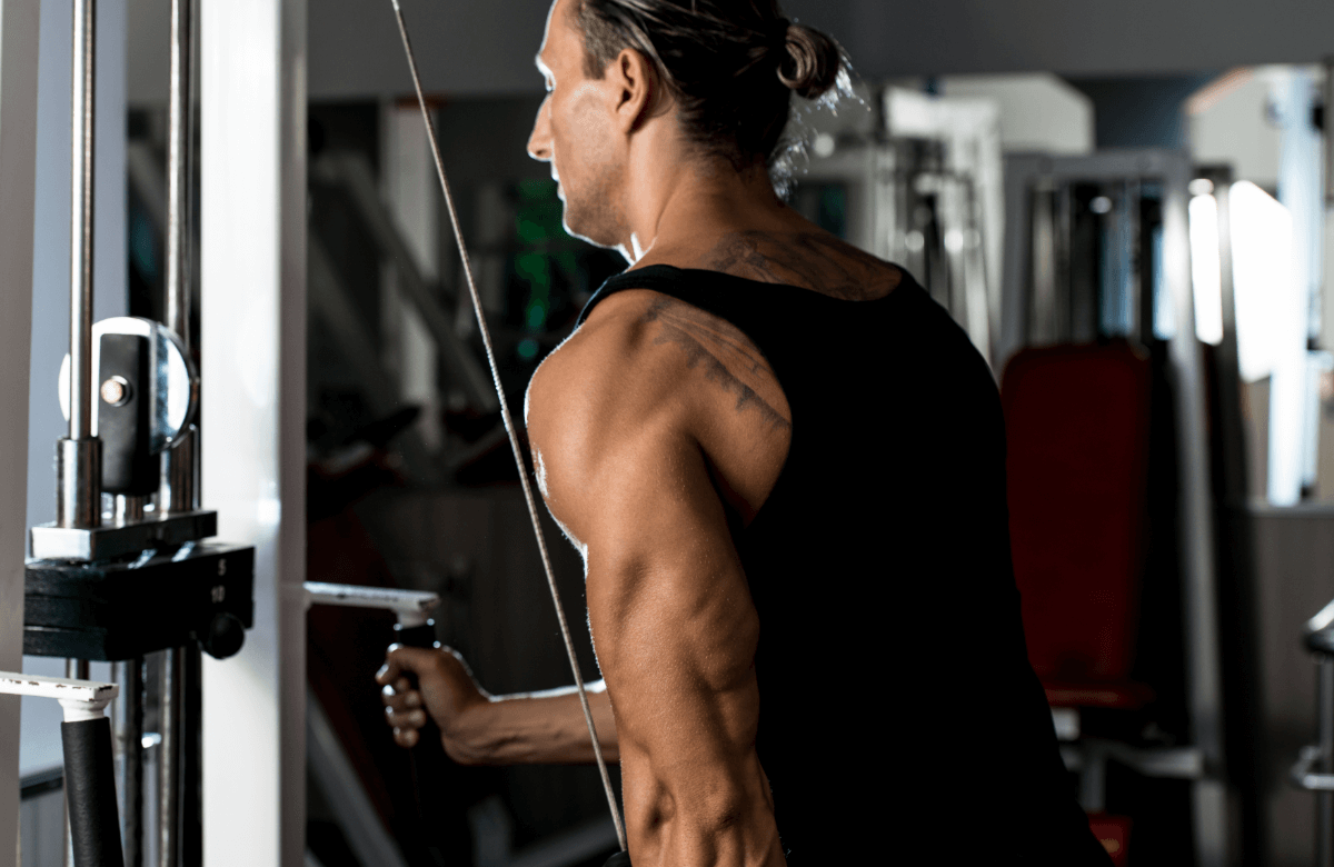 Man does cable pushdown, a long head tricep exercise