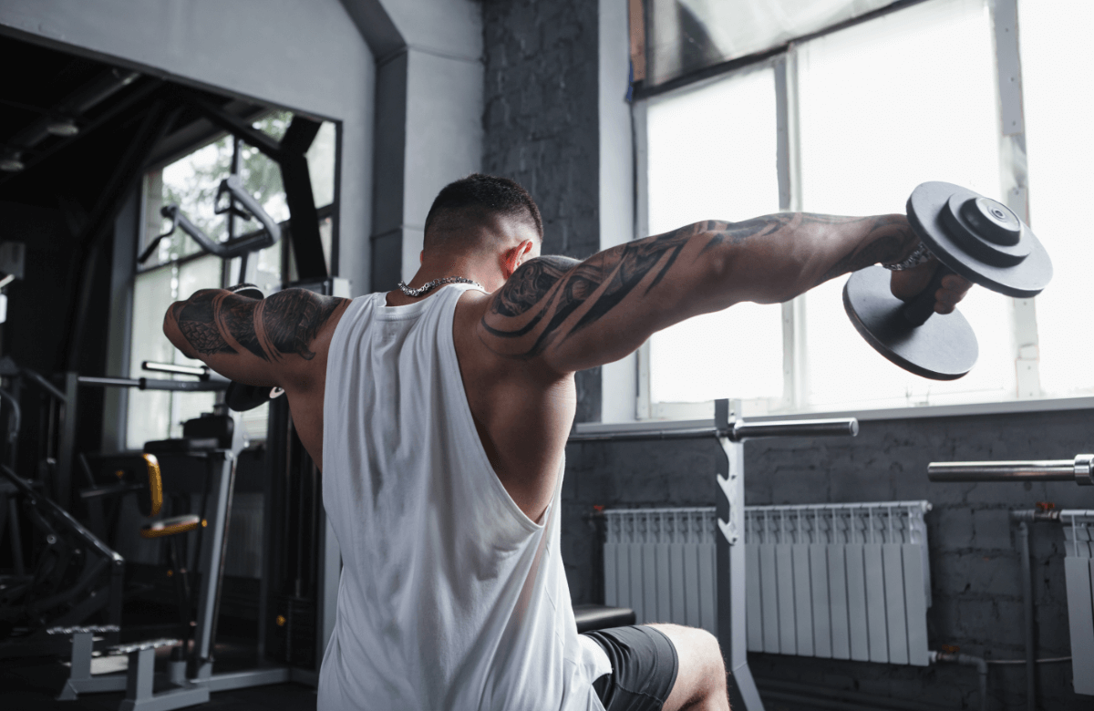 A man does seated lateral raises in a gym