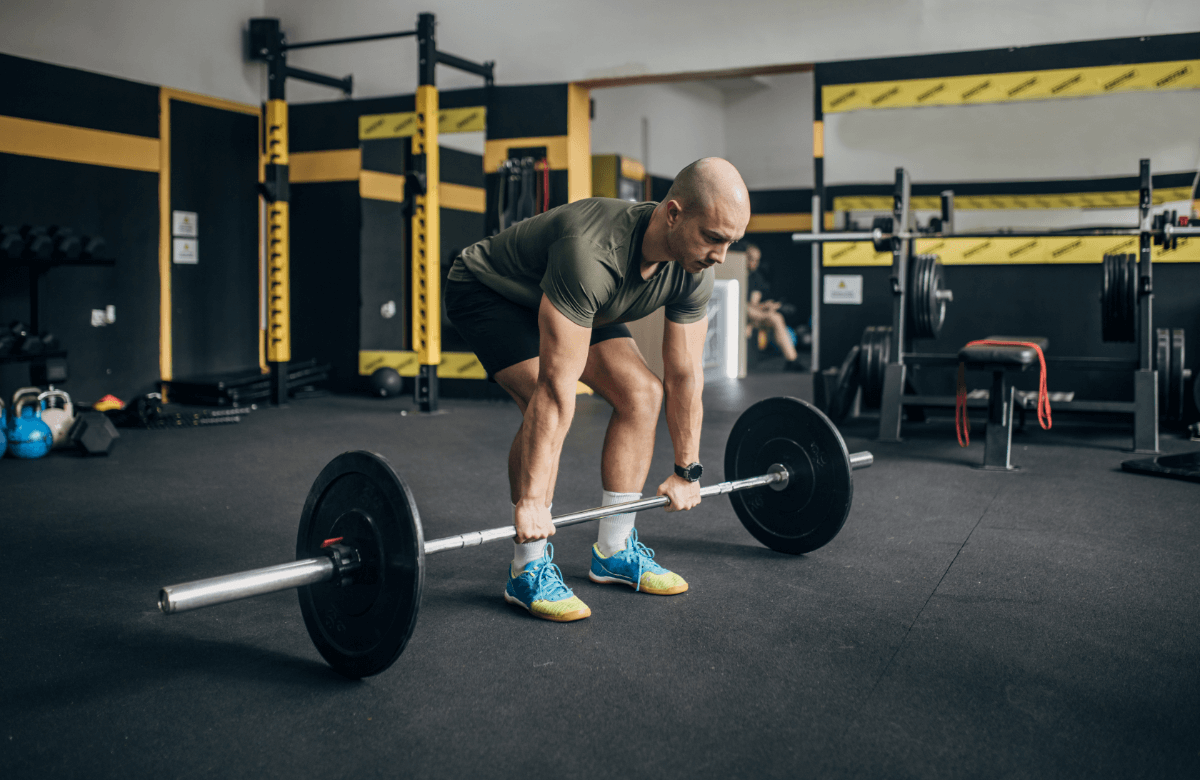 A man does deadlifts in a gym