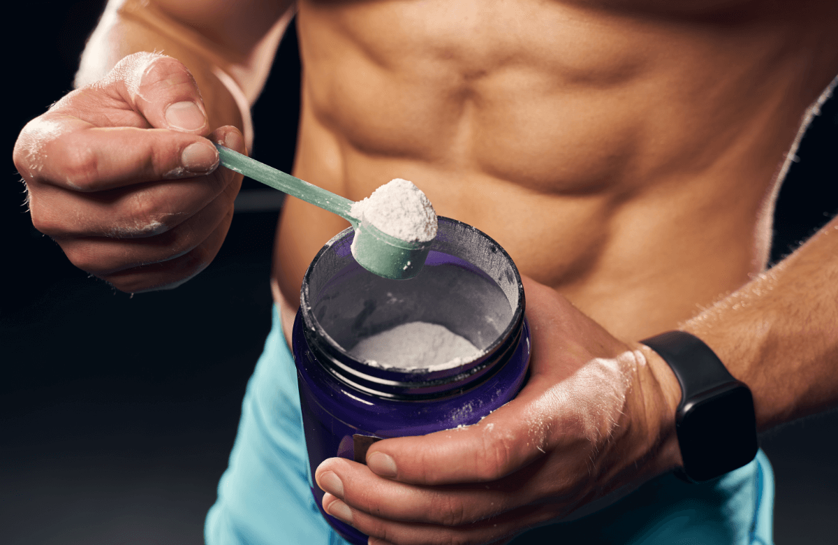 A man takes a spoon of recovery protein powder