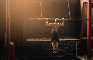 A man exercises on a pull up bar